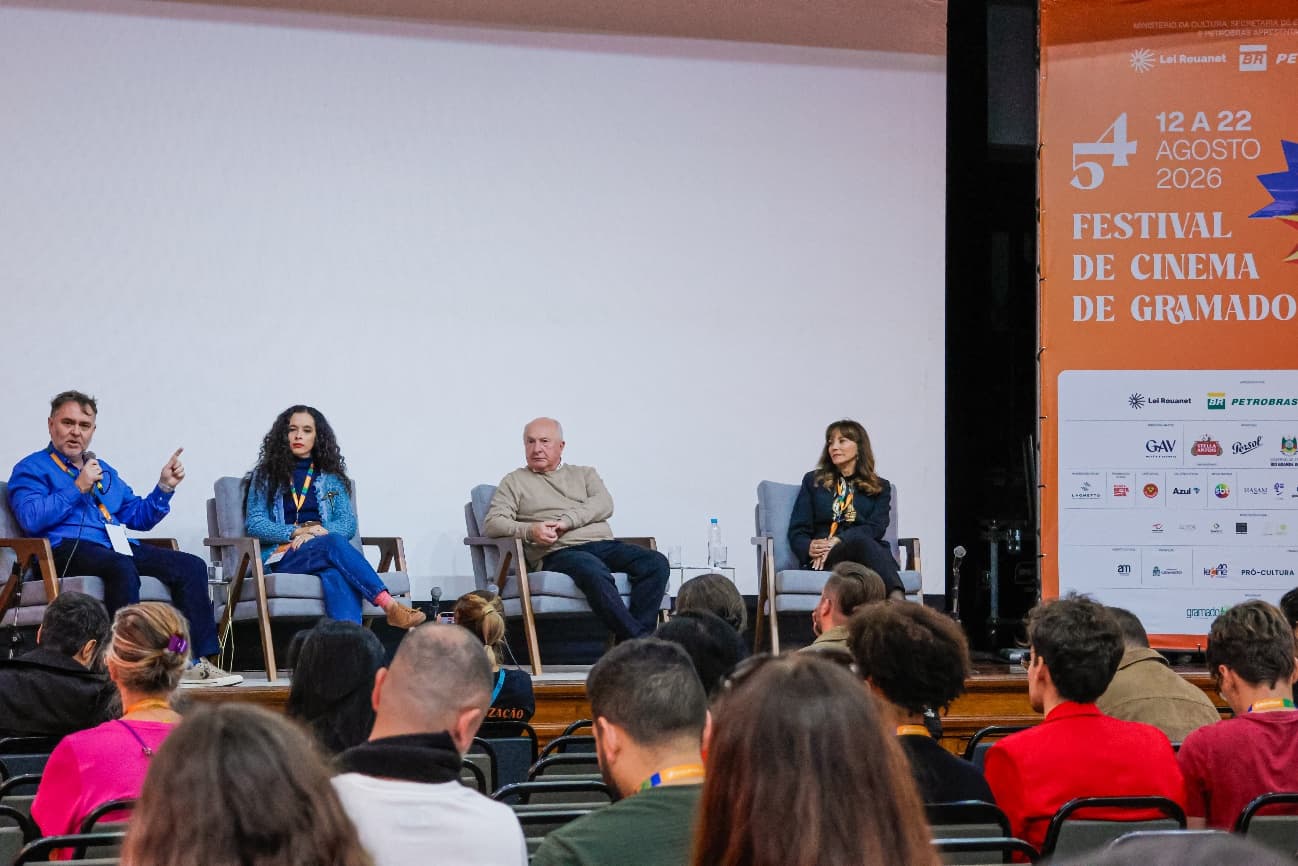 Mesa de debate do Fórum Conexões Gramado Film Market diante de plateia lotada
