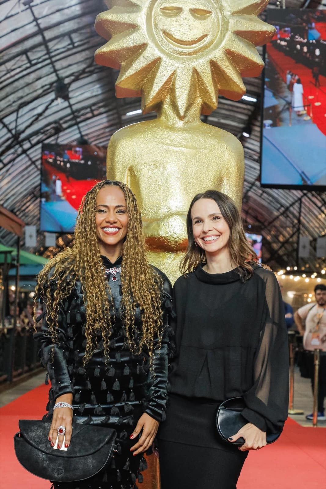 Naruna Costa e Débora Falabella no tapete vermelho, diante da estátua do Kikito